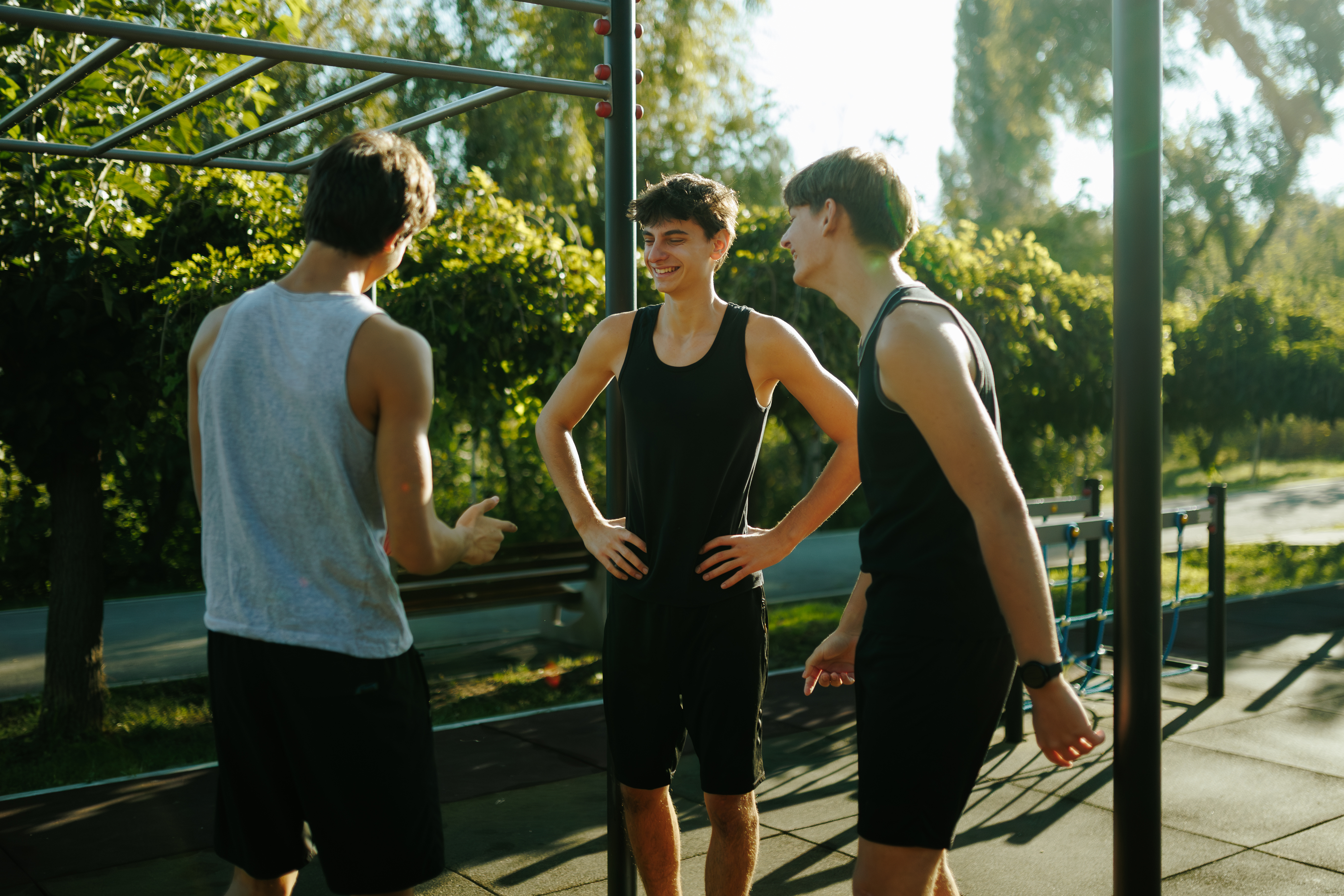 Young athletes chatting together after intensive training, highlighting a healthy summer fitness lifestyle emphasizing group friendship and outdoor relaxation.